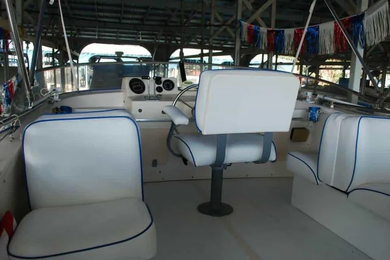 Slide: The Image of 1976 Uniflite Sport Flybridge interior with white seating and steering wheel. - 19