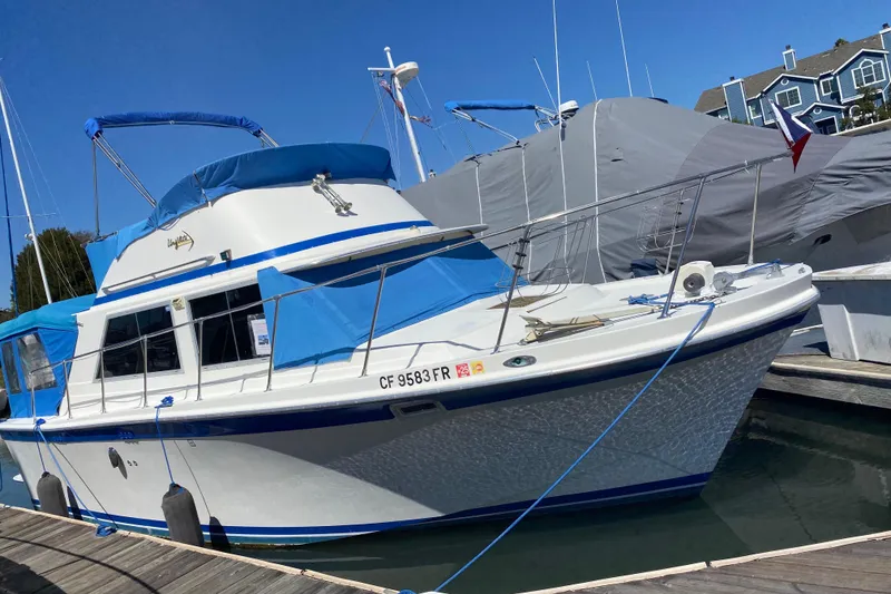 Slide: The Image of 1976 Uniflite Sport Flybridge boat docked, featuring blue accents and covered flybridge. - 3