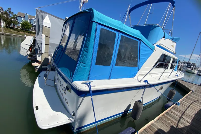 Slide: The Image of 1976 Uniflite Sport Flybridge boat docked with blue canopy and fenders. - 4