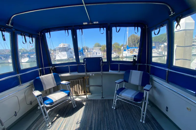 Slide: The Image of 1976 Uniflite Sport Flybridge interior with blue seating and marina view. - 6