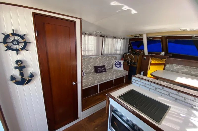 Slide: The Image of 1976 Uniflite Sport Flybridge interior with nautical decor and cozy seating area. - 8