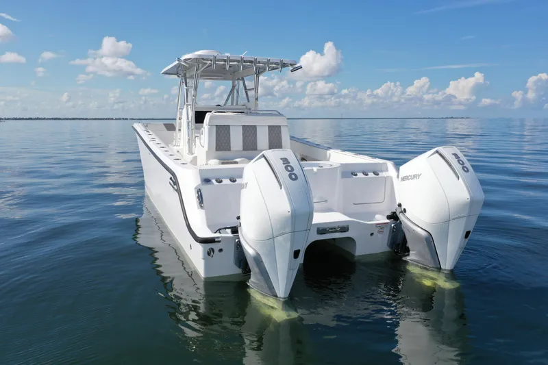 The Image of 2023 Invincible 33 Catamaran with twin Mercury engines on calm ocean waters. - 0