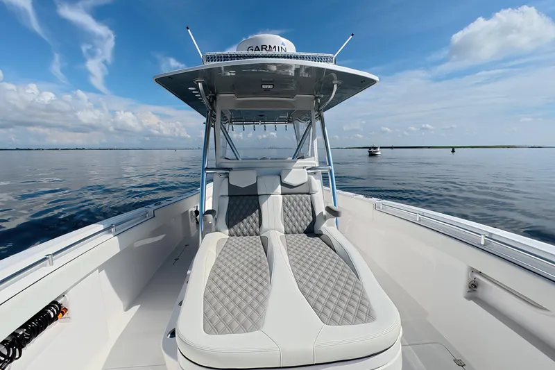 Slide: The Image of 2023 Invincible 33 Catamaran on calm water, featuring sleek seating and modern design. - 21