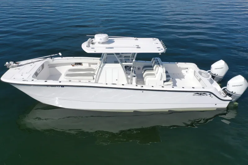 Slide: The Image of 2023 Invincible 33 Catamaran on calm water, featuring dual Mercury engines. - 23