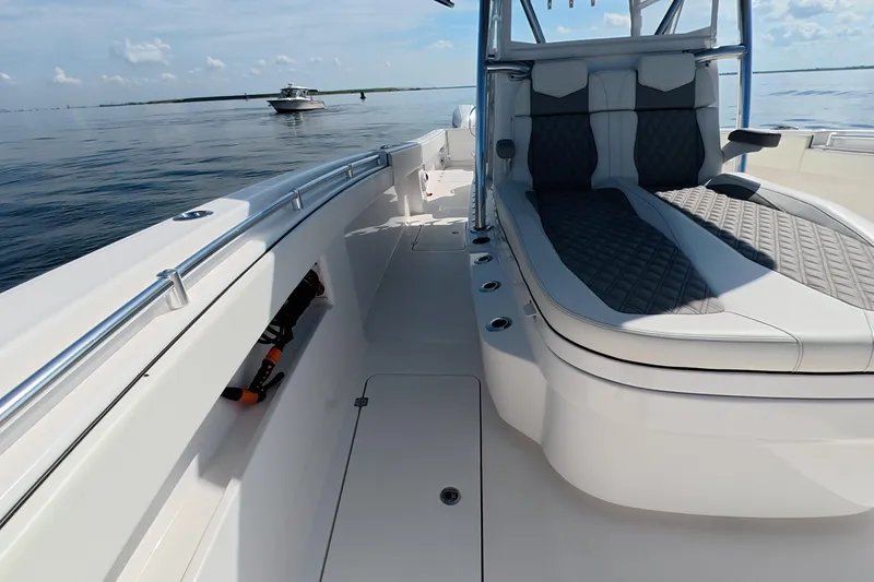 Slide: The Image of 2023 Invincible 33 Catamaran with sleek seating and open deck on calm waters. - 9