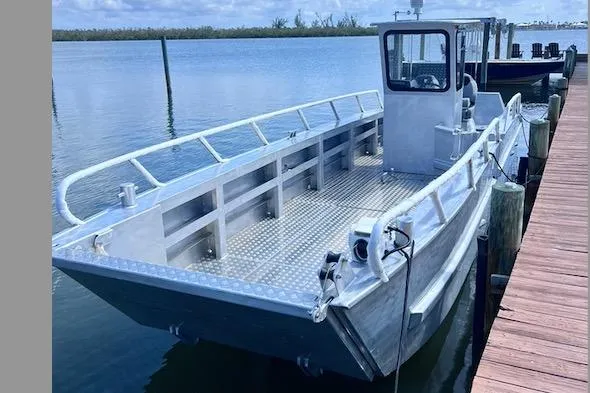 Slide: The Image of 2025 Gospel Boat Landing Craft docked on calm water, featuring sturdy metal construction. - 0