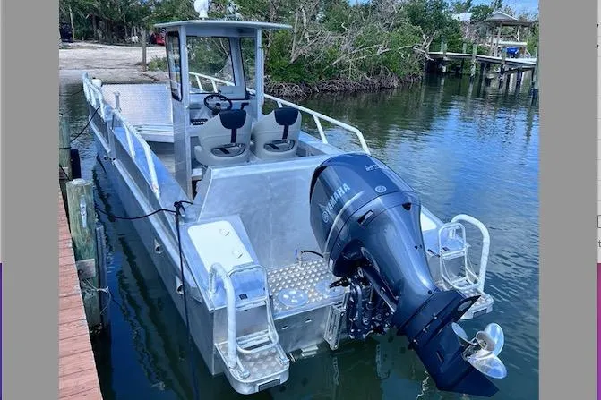 Slide: The Image of 2025 Gospel Boat Landing Craft with Yamaha engine docked on calm water. - 1