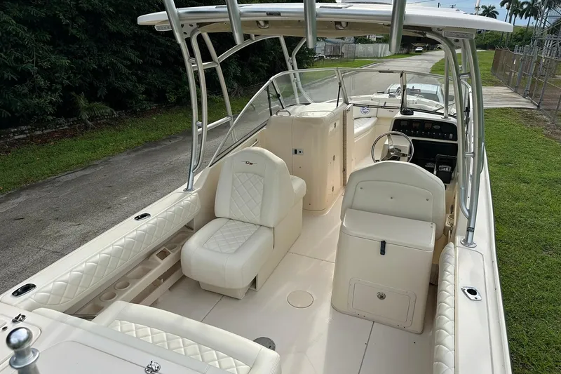 Slide: The Image of 2011 Grady-White Freedom 275 boat interior with white seating and steering console. - 10