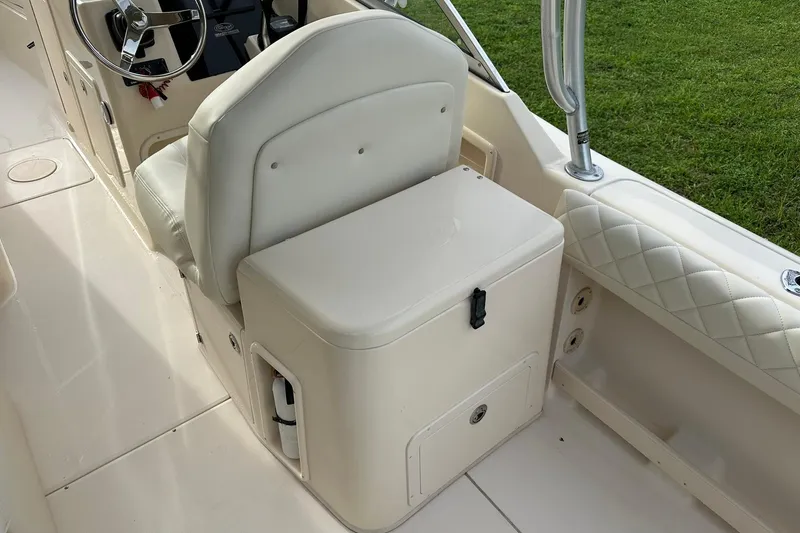 Slide: The Image of 2011 Grady-White Freedom 275 boat interior with white seating and steering wheel. - 16