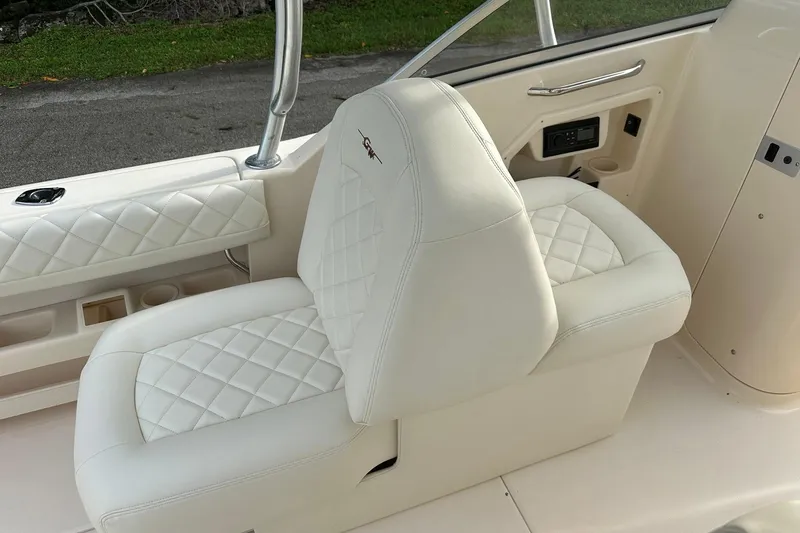 Slide: The Image of Luxurious white seating on a 2011 Grady-White Freedom 275 boat, featuring quilted upholstery. - 18