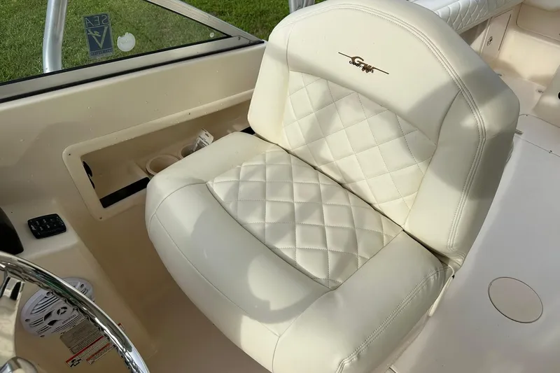Slide: The Image of Luxurious white seat on 2011 Grady-White Freedom 275 boat, featuring quilted design and logo. - 19
