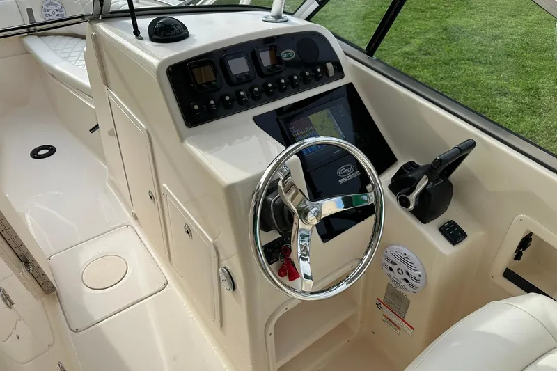 Slide: The Image of 2011 Grady-White Freedom 275 boat dashboard with steering wheel and control panel. - 21
