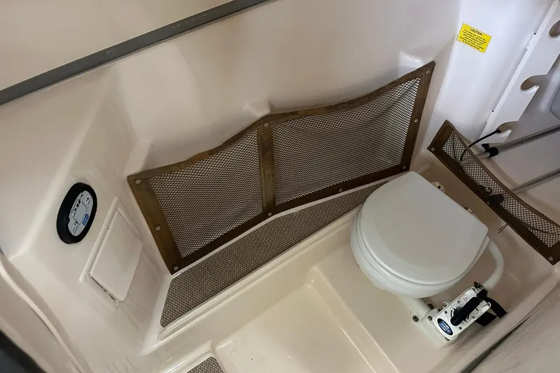 Slide: The Image of 2011 Grady-White Freedom 275 boat interior with toilet and storage netting. - 30