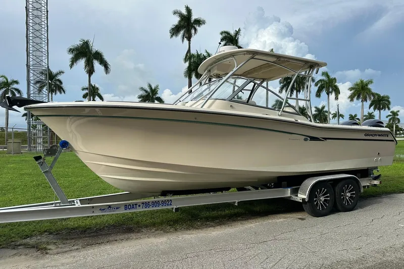 Slide: The Image of 2011 Grady-White Freedom 275 boat on trailer, parked outdoors with palm trees. - 7