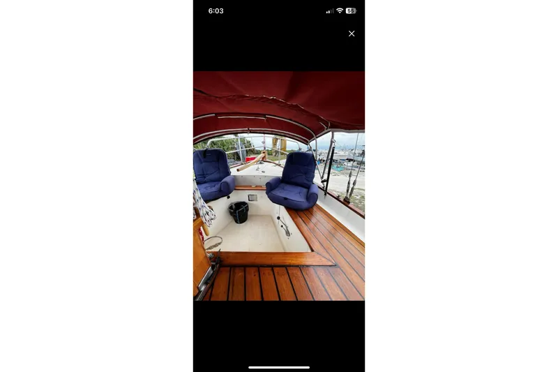 Slide: The Image of Interior of 1975 Dreadnought 32 Ketch with blue seating and wooden deck. - 40