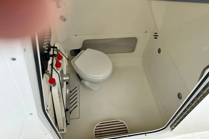 Slide: The Image of 2024 Boston Whaler 250 Outrage boat interior with compact marine toilet. - 20