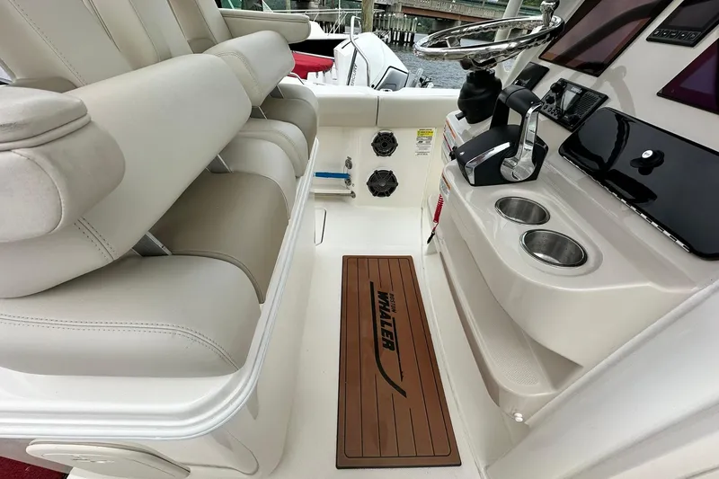 Slide: The Image of 2024 Boston Whaler 250 Outrage interior with helm, seating, and branded flooring. - 21