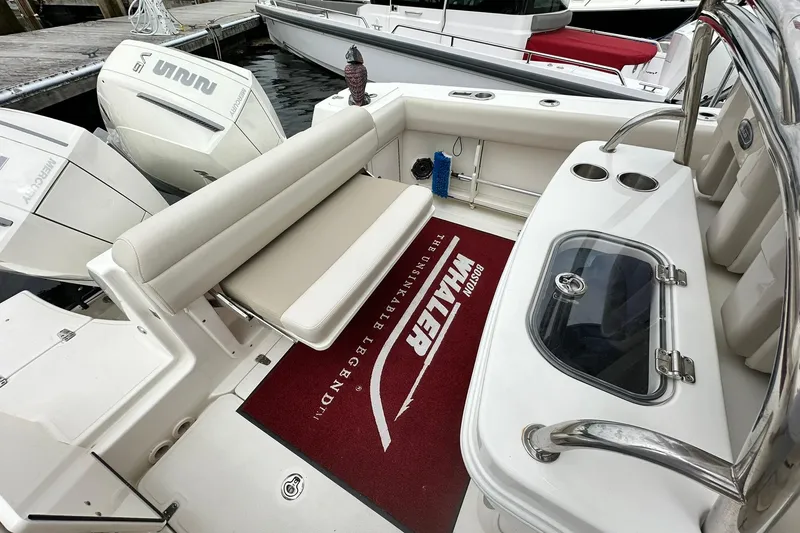 Slide: The Image of 2024 Boston Whaler 250 Outrage boat interior with seating and engine view. - 22