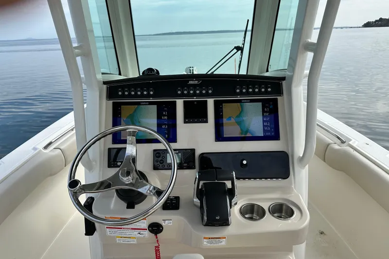 Slide: The Image of 2024 Boston Whaler 250 Outrage helm with dual navigation screens and steering wheel. - 5