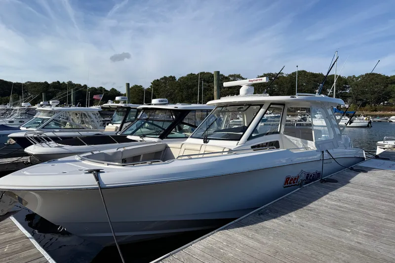 The Image of 2020 Boston Whaler 350 Realm boat docked at a marina under a clear sky. - 0
