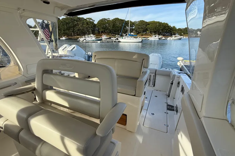 Slide: The Image of Interior of 2020 Boston Whaler 350 Realm boat with luxurious seating and scenic marina view. - 2