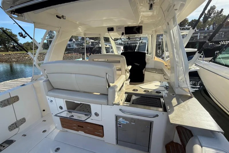 Slide: The Image of 2020 Boston Whaler 350 Realm boat interior with seating and amenities at dock. - 4