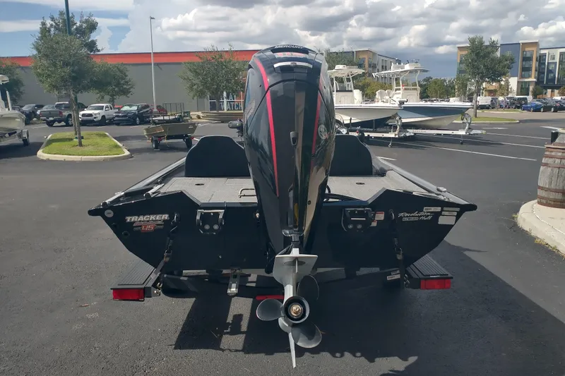 Slide: The Image of 2023 Tracker Pro Team 190 TX boat with Mercury outboard motor in a parking lot. - 2
