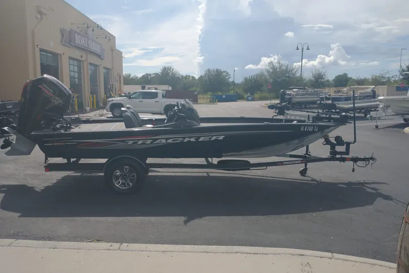 Slide: The Image of 2023 Tracker Pro Team 190 TX boat parked outside a boat service center. - 3
