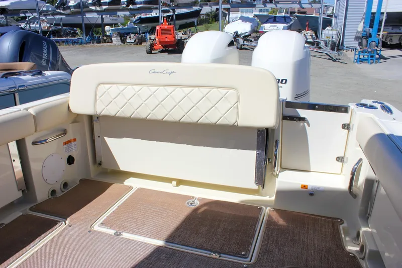Slide: The Image of 2017 Chris-Craft Calypso 26 boat interior with cushioned seating and dual outboard motors. - 10