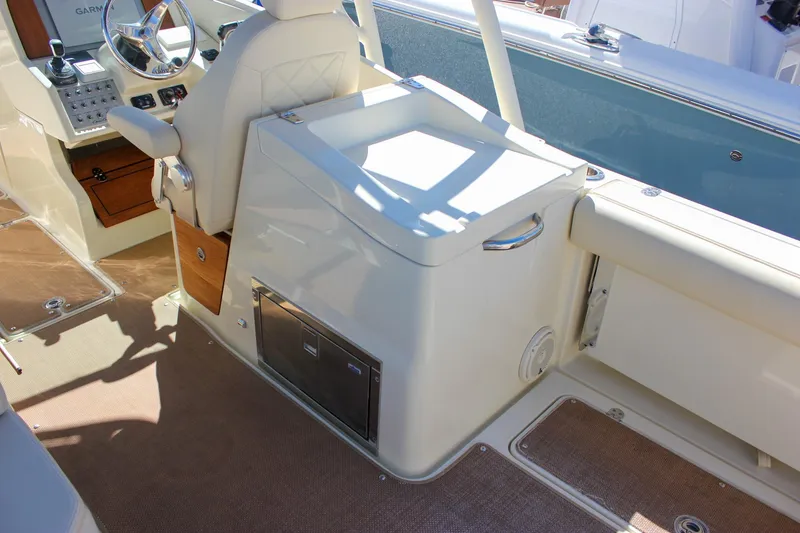 Slide: The Image of 2017 Chris-Craft Calypso 26 boat interior with helm, seating, and storage features. - 11