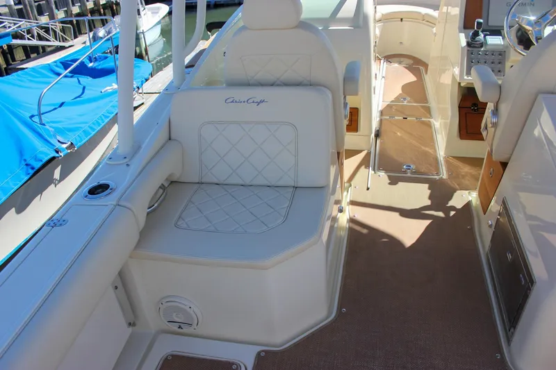 Slide: The Image of 2017 Chris-Craft Calypso 26 boat interior with cushioned seating and control panel. - 12