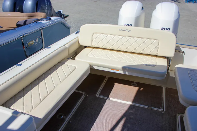 Slide: The Image of 2017 Chris-Craft Calypso 26 boat interior with beige quilted seating and dual Yamaha engines. - 18