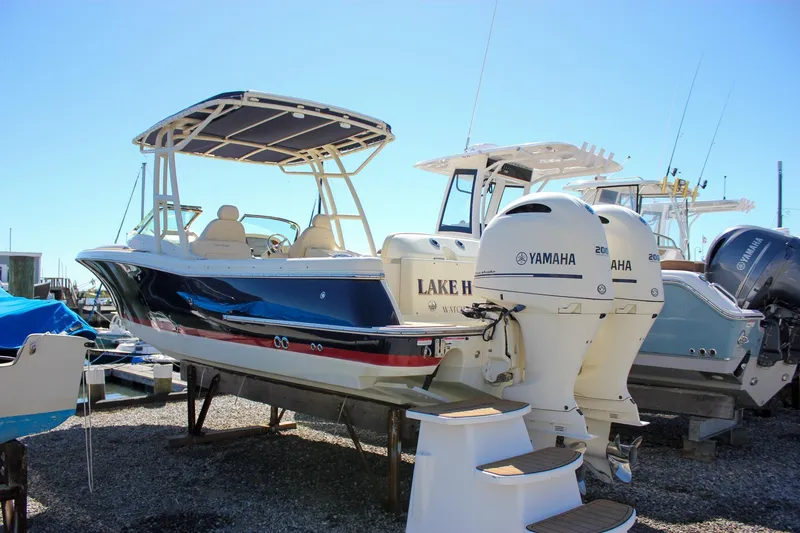 Slide: The Image of 2017 Chris-Craft Calypso 26 boat with Yamaha engines, docked under clear blue sky. - 2