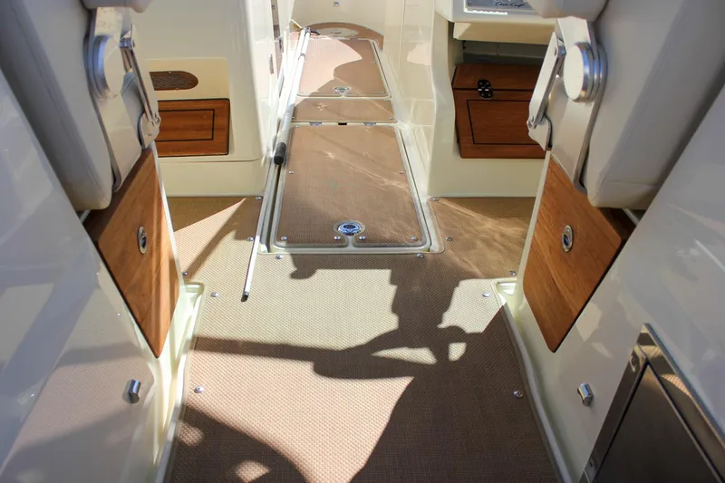 Slide: The Image of 2017 Chris-Craft Calypso 26 interior with wood accents and beige flooring. - 23