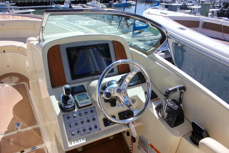 Slide: The Image of 2017 Chris-Craft Calypso 26 boat dashboard with steering wheel and controls. - 29