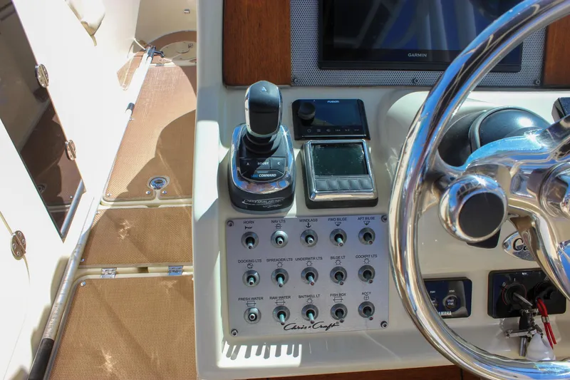 Slide: The Image of Control panel of 2017 Chris-Craft Calypso 26 boat with steering wheel and navigation controls. - 30