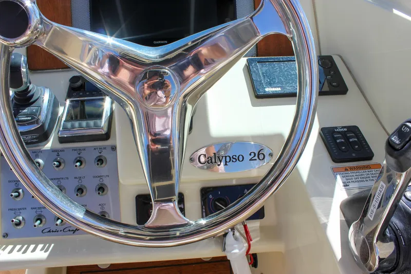 Slide: The Image of 2017 Chris-Craft Calypso 26 boat dashboard with steering wheel and control panel. - 31