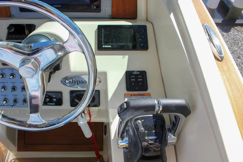 Slide: The Image of 2017 Chris-Craft Calypso 26 boat dashboard with steering wheel and Yamaha controls. - 32