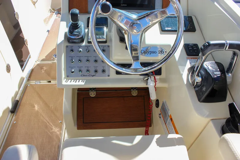 Slide: The Image of 2017 Chris-Craft Calypso 26 helm with steering wheel and control panel. - 34