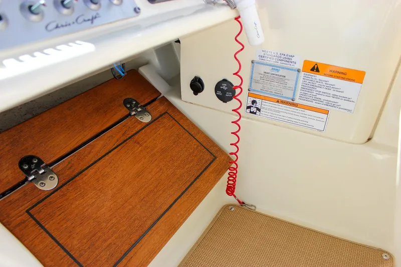 Slide: The Image of 2017 Chris-Craft Calypso 26 dashboard with wooden panel and safety warnings. - 35