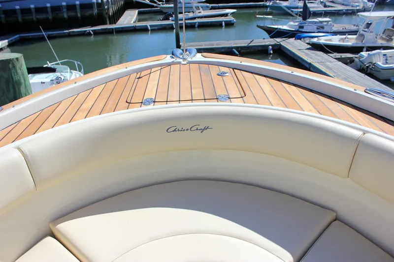 Slide: The Image of 2017 Chris-Craft Calypso 26 boat with teak deck and cushioned seating at marina. - 38