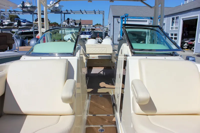 Slide: The Image of 2017 Chris-Craft Calypso 26 boat interior with cream seating and dual windshields. - 39