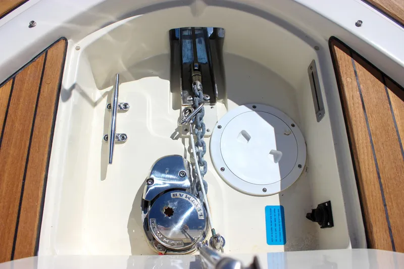 Slide: The Image of Anchor compartment of 2017 Chris-Craft Calypso 26 with teak accents and chain mechanism. - 40