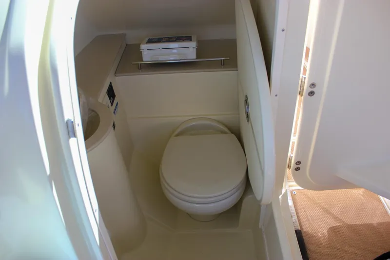 Slide: The Image of 2017 Chris-Craft Calypso 26 boat interior bathroom with toilet and storage shelf. - 47