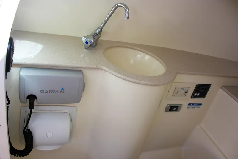 Slide: The Image of 2017 Chris-Craft Calypso 26 interior with sink, Garmin device, and control panel. - 49