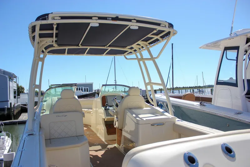 Slide: The Image of 2017 Chris-Craft Calypso 26 boat interior with seating and helm, docked at marina. - 52