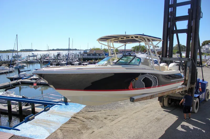 Slide: The Image of 2017 Chris-Craft Calypso 26 boat being lifted at a marina. - 55