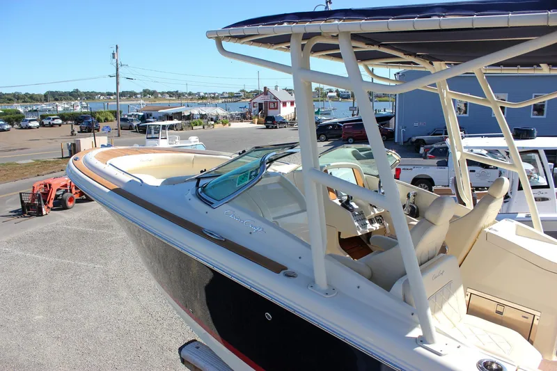 Slide: The Image of 2017 Chris-Craft Calypso 26 boat docked, showcasing sleek design and luxurious seating. - 58