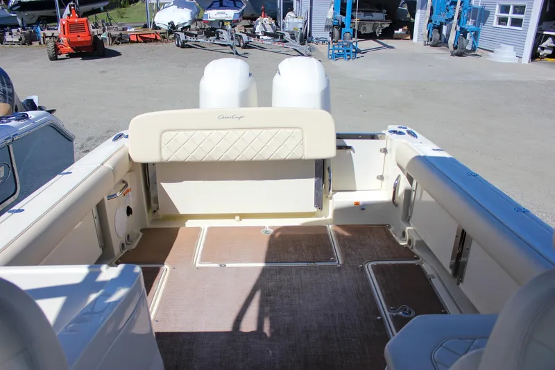 Slide: The Image of 2017 Chris-Craft Calypso 26 boat interior with seating and storage, docked outdoors. - 8