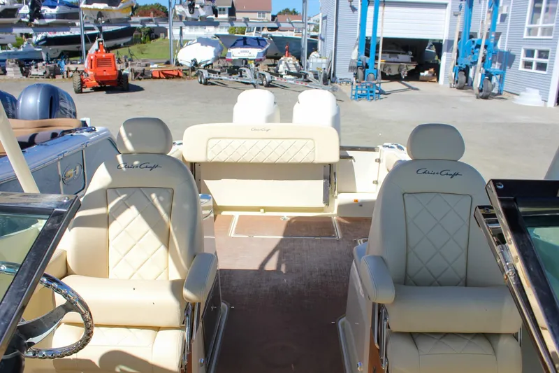 Slide: The Image of 2017 Chris-Craft Calypso 26 boat interior with beige seating and steering wheel. - 9